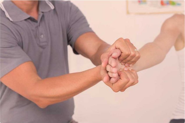 Therapeut und Patient beim Handgriff